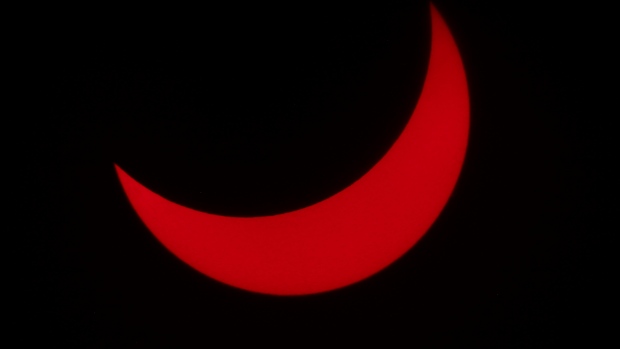A photo of the partial eclipse, appearing red.