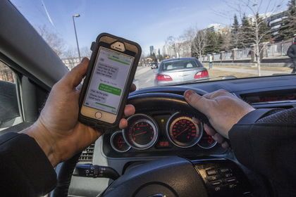 Toronto Sun image of a driver using an iPhone behind the wheel