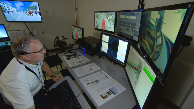TTC senior trainer Lionel Jordan sits behind control monitors that allow him to monitor and manipulate conditions in the simulator. (CBC)