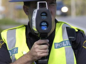 An OPP officer uses a radar gun to measure speeds of vehicles.