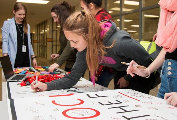 Hundreds of students take the “pledge” by signing a banner that will be displayed in the school cafeteria as a constant reminder to not drive distracted. - Taylor Bertelink