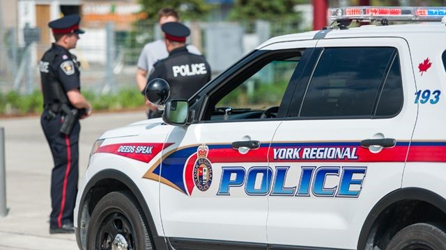 York Regional Police officers standing in front of a YRP cruiser