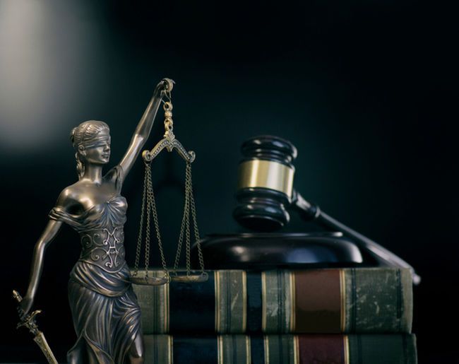 Blind justice statue next to a gavel