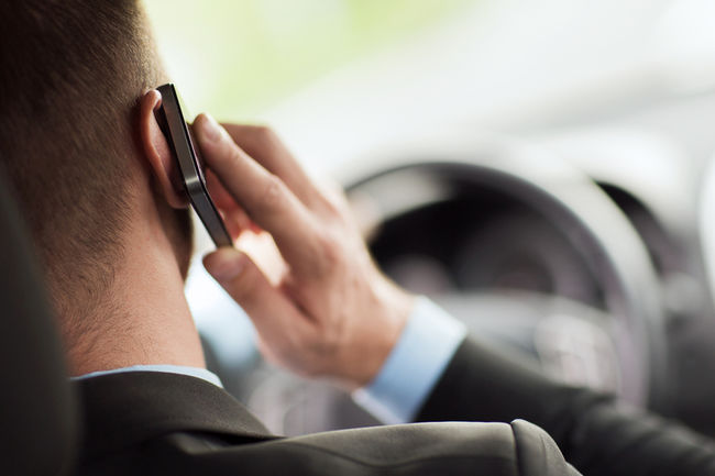 File photo of a man holding a phone to his ear while driving