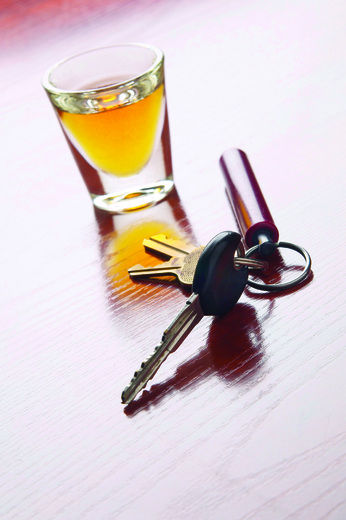 Alcohol in a shot glass next to keys