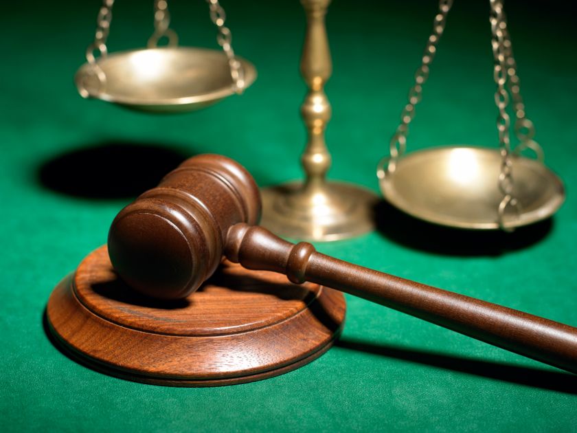 stock image of gavel and scale on a green felt backdrop