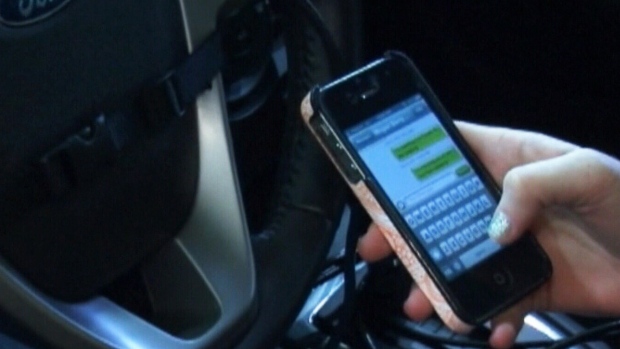 A woman uses an iPhone in the driver's seat of a Ford vehicle.