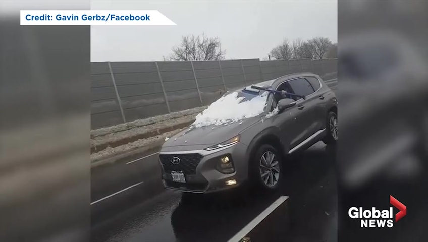 Video appears to show motorist clearing windshield of snow while driving on Toronto highway