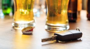 Stock image of a car key in front of glasses of alcohol