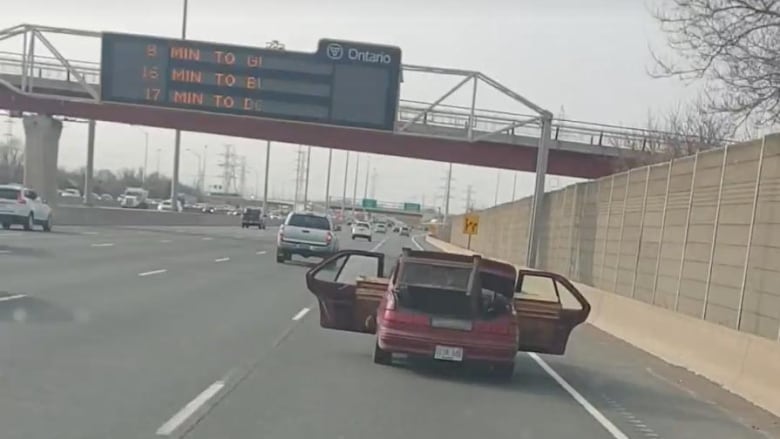 Man driving with car doors open on QEW charged