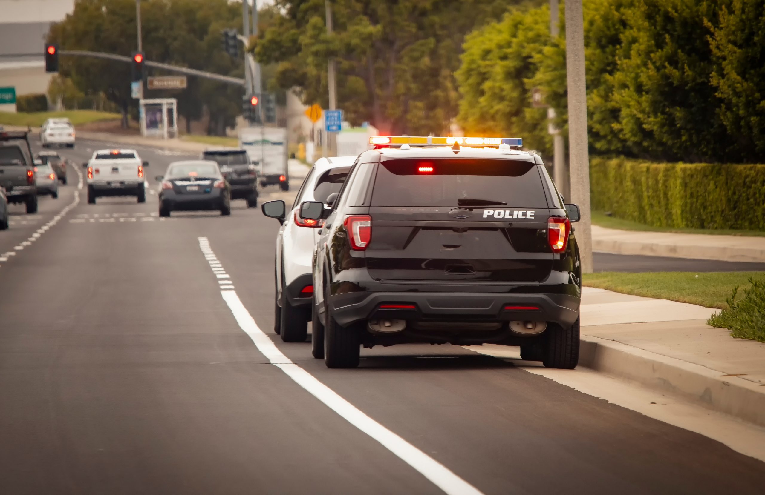 Police SUV conducting a traffic stop on a city street.